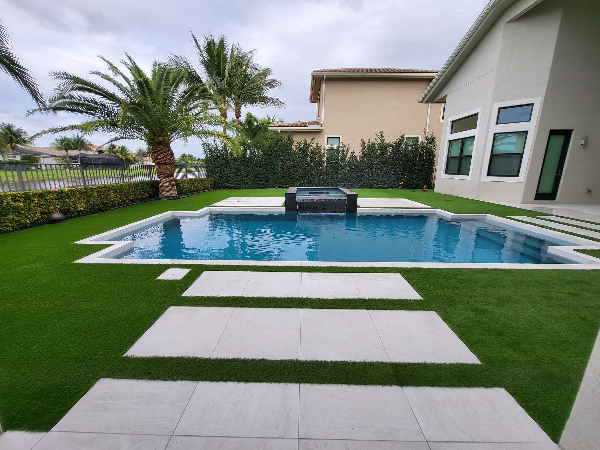 Premium artificial grass installation with paver inlay